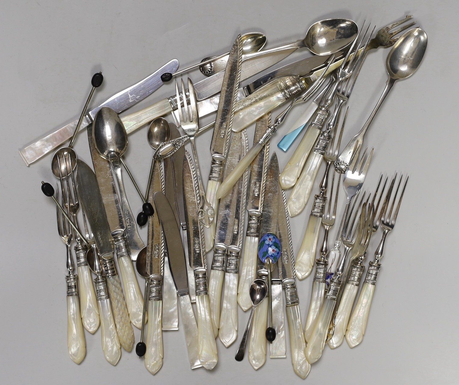 A selection of mounted mother-of-pearl knives and forks, together with finely decorated enamelled spoons
